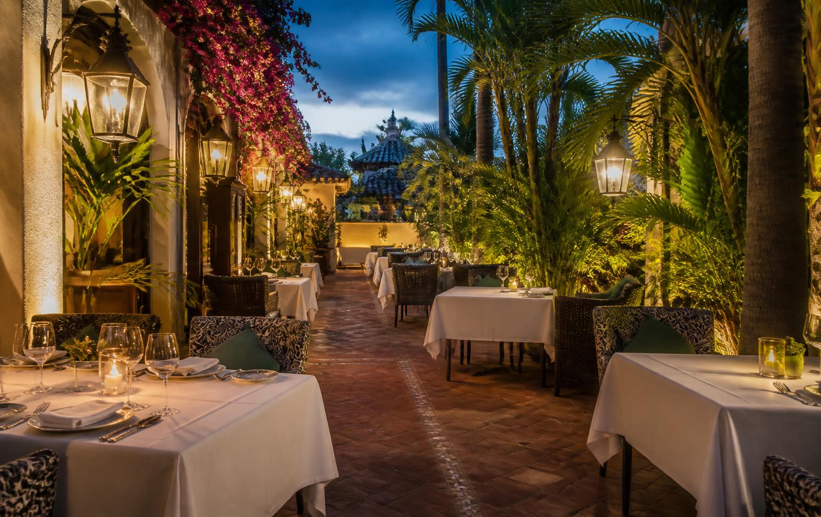 Elegant garden restaurant terrace in Marbella set for dinner at dusk